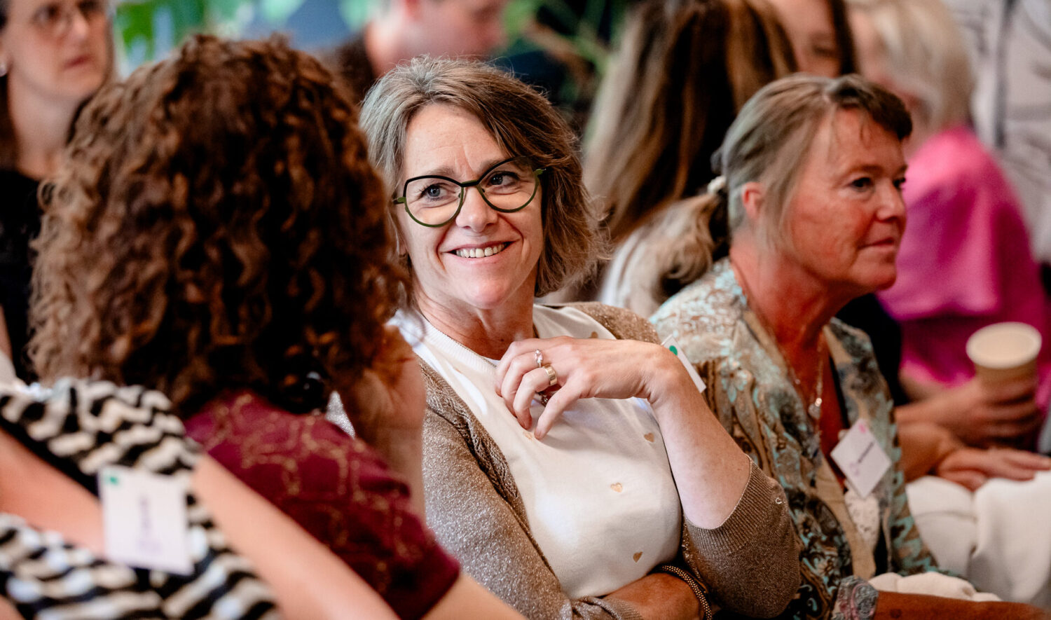 Vrouwen in gesprek tijdens inspirerend netwerkevent met koffie en badges